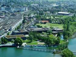 Popup-Link: Luftbild der Hochschule Rapperswil; das Gebäude liegt direkt am oberen Zürichsee und neben dem Bahnhof Rapperswil