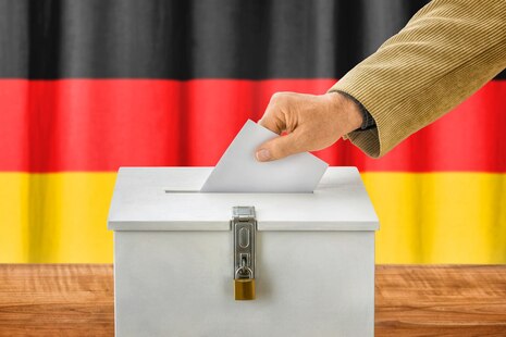 Das Bild zeigt eine Wahlurne mit Deutschlandfahne.